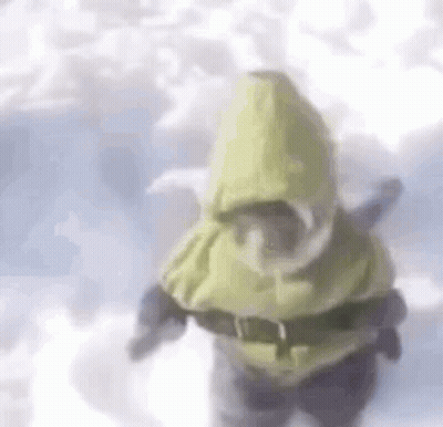 A Person Is Standing In The Snow Wearing A Yellow Hooded Jacket And Goggles . GIF