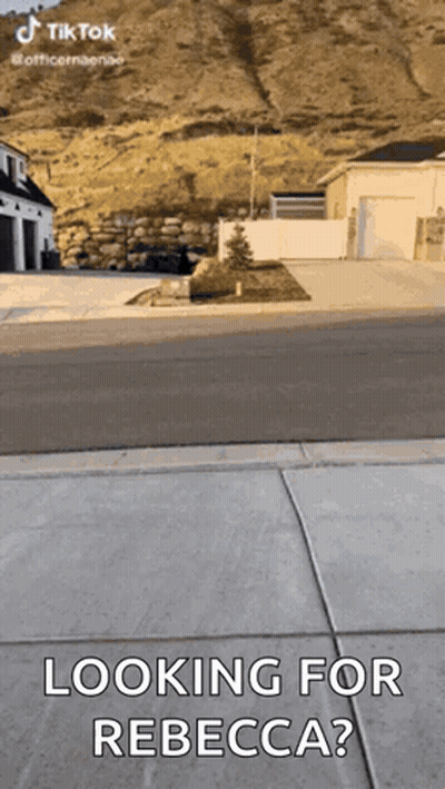 A Person Is Standing On A Sidewalk And Looking For Rebecca . GIF