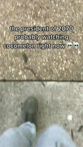 A Person Is Standing On A Sidewalk With A Caption That Says The President Of 2070 Probably Watching Cocomelon Right Now GIF