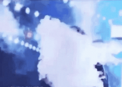 A Person Is Standing On A Stage With Smoke Coming Out Of It . GIF