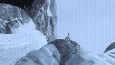 A Person Is Standing On Top Of A Snowy Mountain GIF
