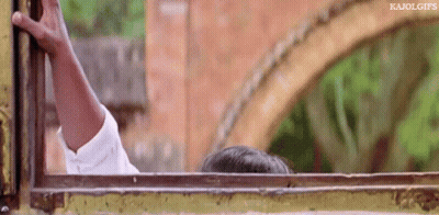 A Person Is Sticking Their Head Out Of A Window With A Brick Wall In The Background . GIF