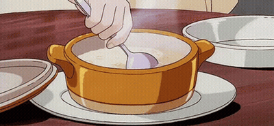 A Person Is Stirring A Bowl Of Soup With A Spoon On A Table . GIF