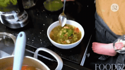 A Person Is Stirring A Bowl Of Soup With A Spoon With The Number 52 On The Bottom GIF