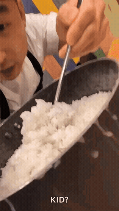 A Person Is Stirring Rice In A Pan With A Spoon And The Word Kid Is Visible GIF