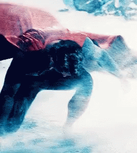 A Person Is Swimming In A Pool With A Red Cape On GIF