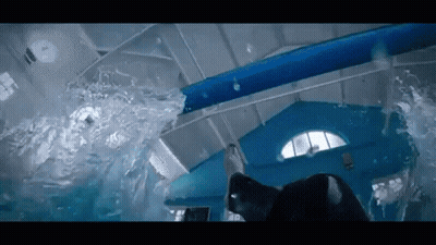 A Person Is Swimming In A Pool With A Water Slide . GIF