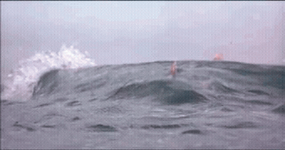 A Person Is Swimming In The Ocean With Waves Crashing Against Them GIF