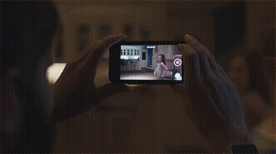 A Person Is Taking A Picture Of A Little Girl On A Phone GIF