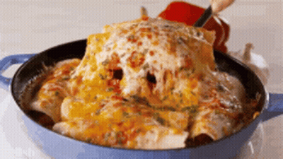 A Person Is Taking A Tortilla Out Of A Pan With Cheese On Top . GIF