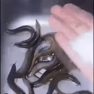 A Person Is Touching A Bunch Of Fish In A Sink With Their Hand . GIF