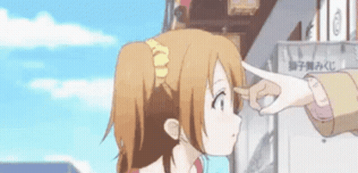 A Person Is Touching A Girl 'S Forehead With Their Finger While Standing In Front Of A Building . GIF