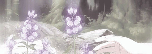 A Person Is Touching A Purple Flower In A Field . GIF