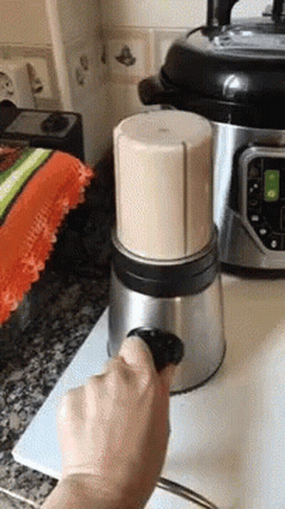 A Person Is Using A Blender To Make A Drink In A Kitchen GIF