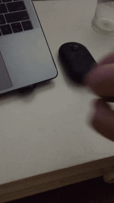 A Person Is Using A Mouse Next To A Laptop Computer GIF