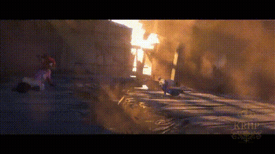 A Person Is Walking Down A Street In Front Of A Building . GIF
