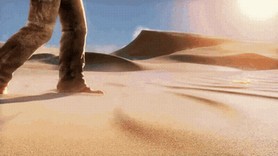 A Person Is Walking Through A Sandy Desert Landscape GIF
