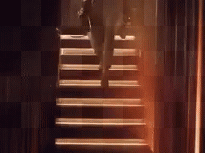 A Person Is Walking Up A Set Of Stairs . GIF