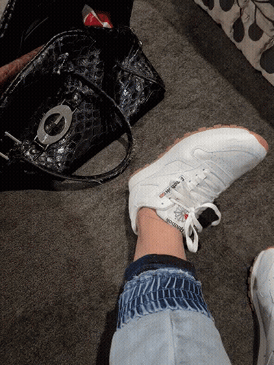 A Person Is Wearing A Pair Of White Reebok Sneakers GIF