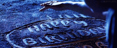 A Person Is Writing The Word Happy Birthday On The Ground . GIF