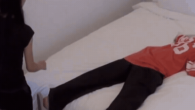 A Person Laying On A Bed Wearing A Red Shirt With The Number 20 On It GIF