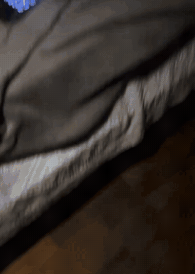 A Person Laying On A Bed With A Blanket On GIF