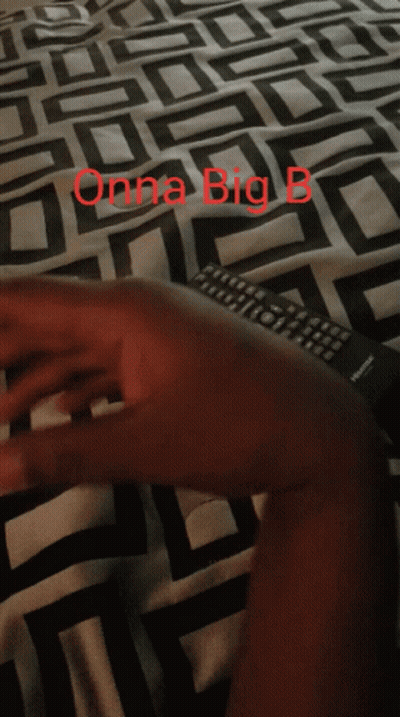 A Person Laying On A Bed With A Blanket That Says Onna Big B On It GIF