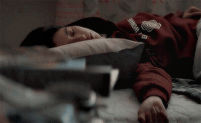 A Person Laying On A Bed With A Sweatshirt On That Says Harvard GIF