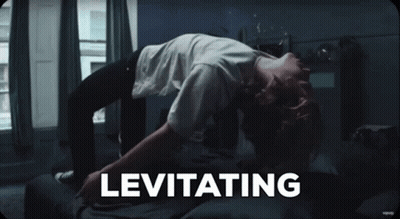 A Person Laying On A Bed With The Word Levitating Written Above Them GIF
