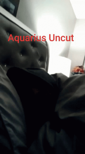A Person Laying On A Bed With The Words Aquarius Uncut On The Bottom Right GIF