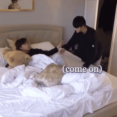 A Person Laying On A Bed With The Words Come On Written On The Bottom GIF
