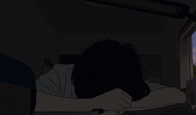 A Person Laying On A Bed With Their Head In Their Hands In The Dark GIF