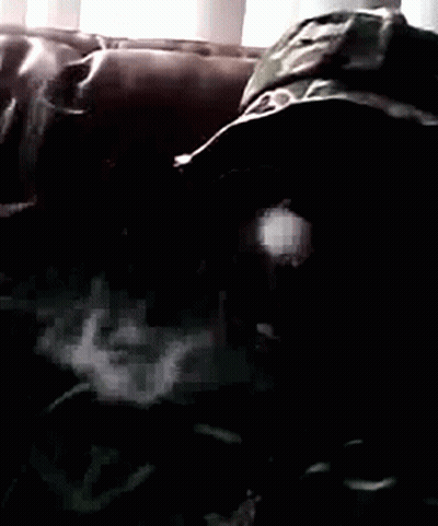 A Person Laying On A Couch Wearing A Camouflage Hat GIF