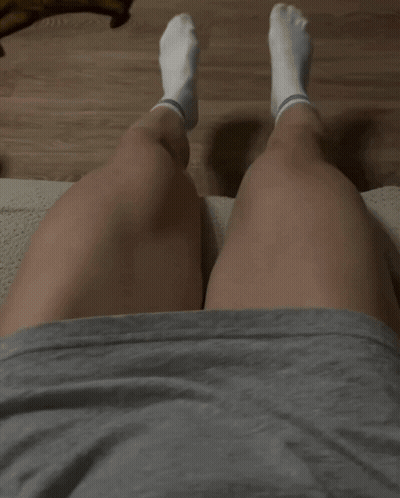 A Person Laying On A Couch With Their Legs Crossed Wearing White Socks GIF
