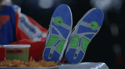 A Person Laying On A Table With Their Feet Up And A Tray Of French Fries . GIF