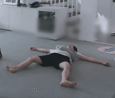 A Person Laying On The Floor With Their Legs Crossed GIF