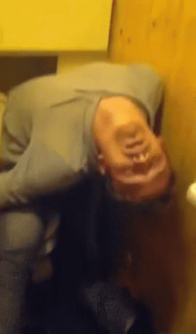 A Person Laying On Their Back With Their Head On A Table GIF