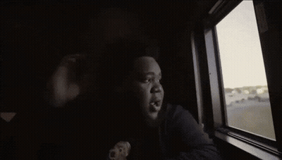 A Person Looking Out Of A Window With A Hole In It GIF