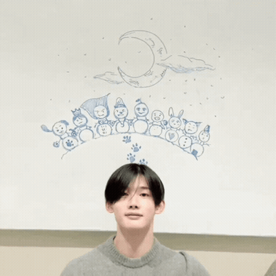 A Person Making A Heart With Their Hands In Front Of A Drawing Of Snowmen And A Crescent Moon GIF
