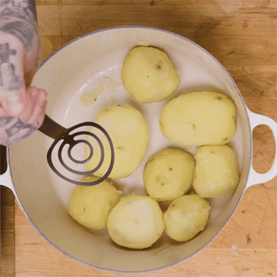 A Person Mashing Potatoes In A White Pot GIF