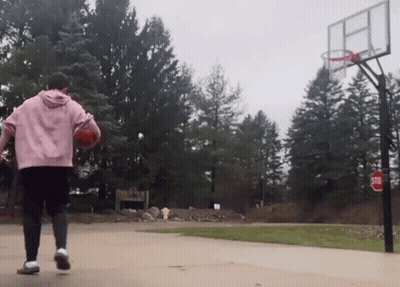 A Person Playing Basketball On A Court With A Stop Sign In The Background GIF