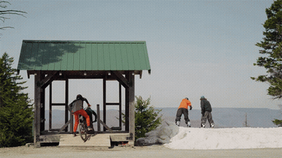 A Person Riding A Bike In Front Of A Green Roof GIF
