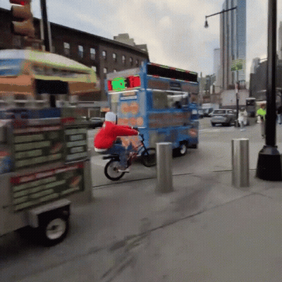 A Person Riding A Bike Next To A Food Truck That Says ' Ice Cream ' On The Side GIF
