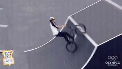 A Person Riding A Bike On A Track With The Olympic Channel Logo GIF