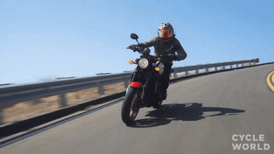A Person Riding A Motorcycle On A Road With The Words Cycle World Visible GIF