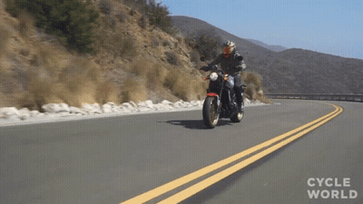 A Person Riding A Motorcycle On A Road With The Words Cycle World Written On The Bottom GIF