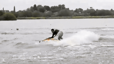 A Person Riding A Surfboard In The Water GIF