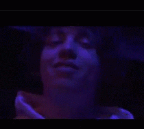 A Person 'S Arm Is Glowing In A Purple Light . GIF
