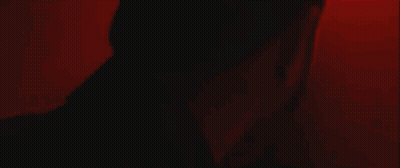 A Person 'S Arm Is Visible In A Dark Room With A Red Light Behind Them . GIF