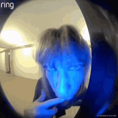 A Person 'S Face Is Visible Through A Doorbell With Ring Written On The Bottom GIF